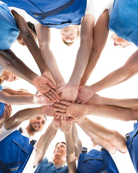 Directly below shot of janitors stacking hands in huddle against white background.jpg