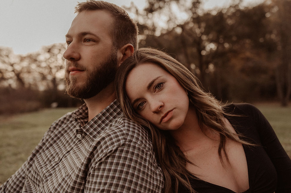 A couple rests their backs together for a fall photo session.