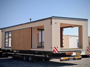 Schwertransport eines ViNord Integri Tiny Houses - zwei überbreite Module auf Spezial-LKW mit Begleitfahrzeugen unterwegs durch Österreich