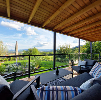 Terrasse des Johannesbachklamm Chalets mit komfortablen Außenmöbeln und schöner Aussicht.