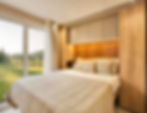 Gemütliches Schlafzimmer mit Doppelbett und Holzdekor in einem ViNord Tiny House aus Österreich