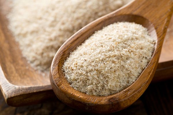Heap of psyllium husk in wooden spoon and bowl on table. Psyllium husk also called isabgol