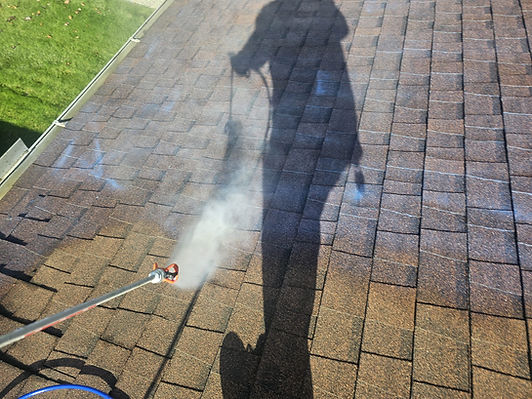 Clear protective treatment being sprayed on asphalt shingles