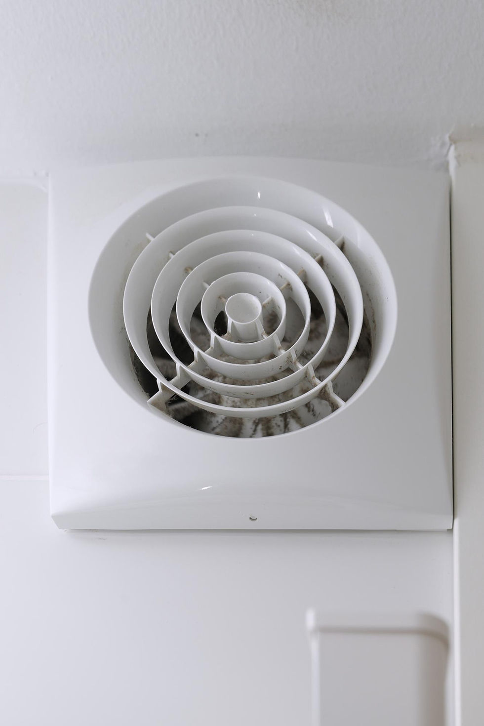 Ceiling vent with visible dirt and dust buildup in a white housing.