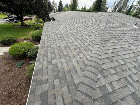 Asphalt shingle roof with multiple slopes and a central hip