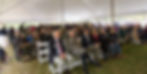 Guests under a white tent at the opening of Alumni House.