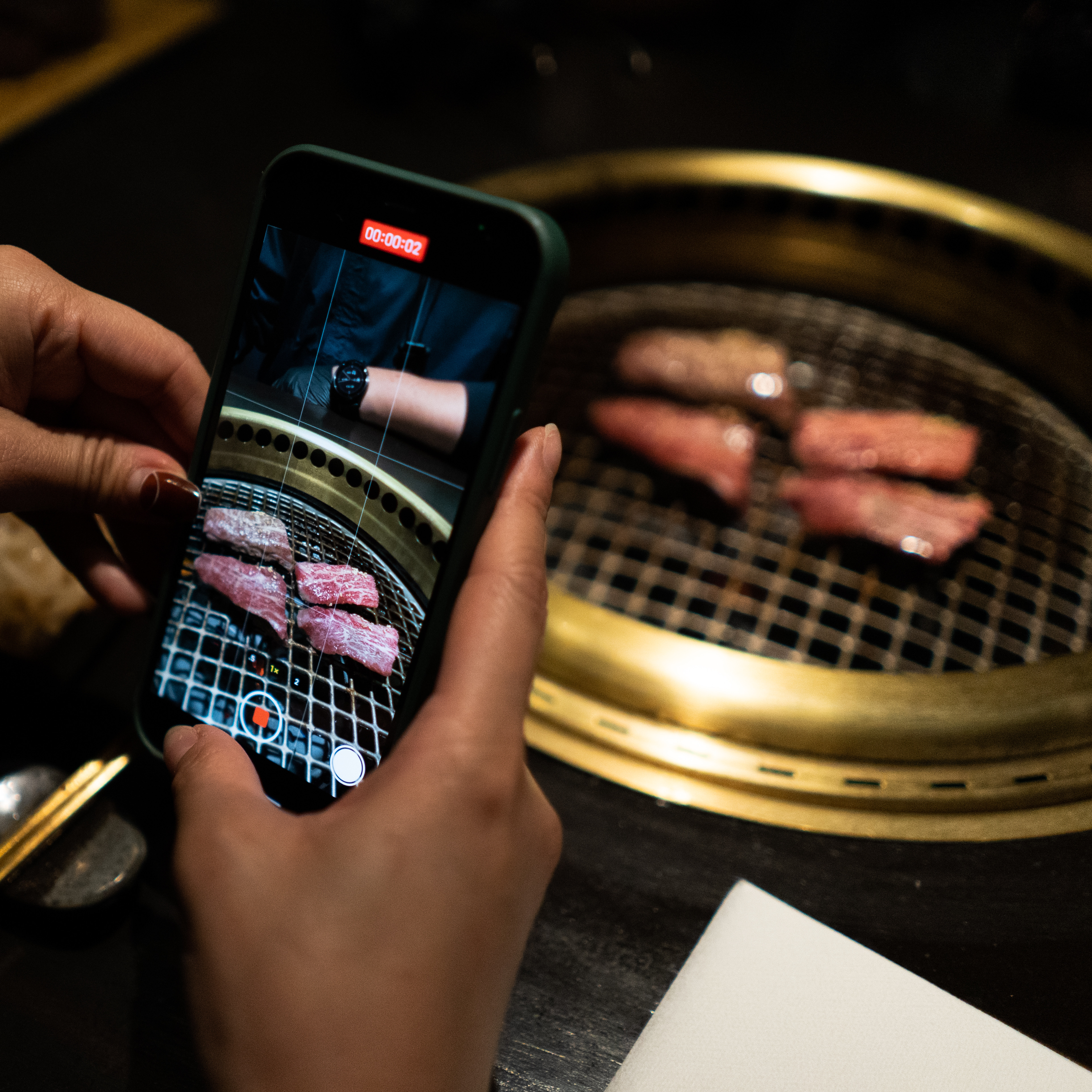 Guest photographing Wagyu at the grill