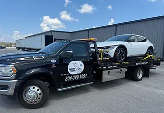 Tow truck with a white car and equipment.webp