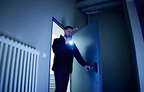 Mature Male Security Guard With Flashlight Standing In Corridor stock photo.jpg