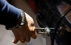 A Close-Up of a Hand Using Pliers to Manipulate a Car Door Lock stock photo.jpg
