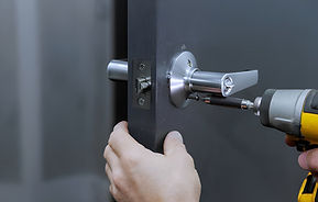 Installing lock handles on room doors with screwdriver by a carpenter stock photo.jpg