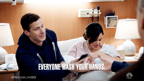 Man saying "everyone wash your hands" while his wife is holding their baby