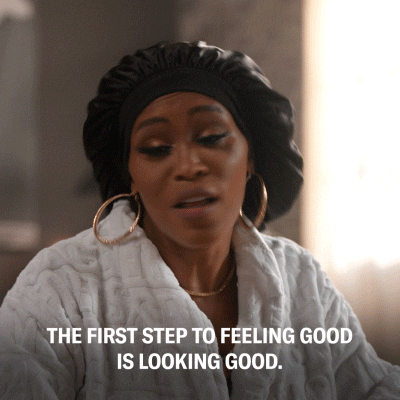 Black woman in a white badrobe wearing a black night cap saying "the first step to feeling good is looking good"