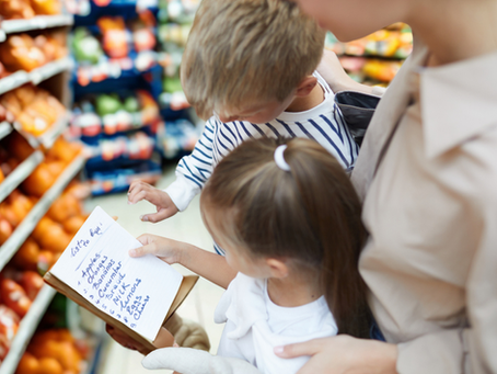 Une mère prépare la liste d'épicerie avec ses enfants.
