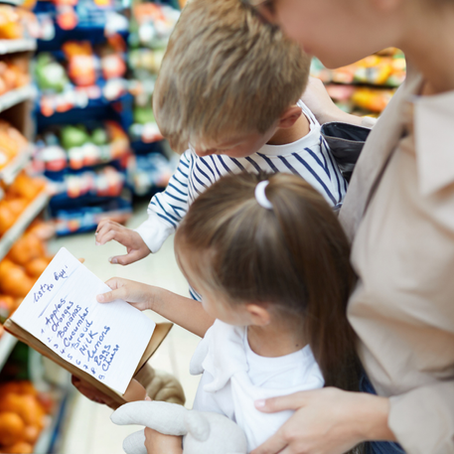 Une mère prépare la liste d'épicerie avec ses enfants. 