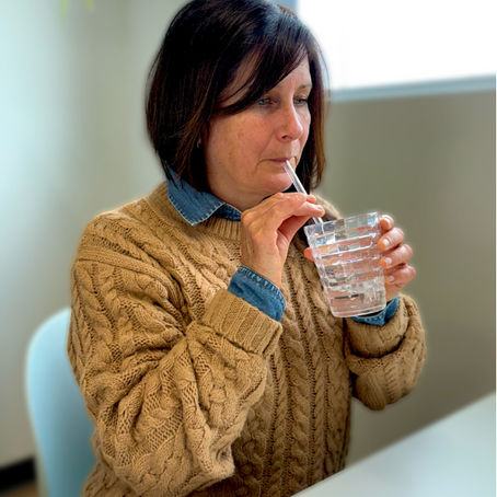 Cliente qui fait un exercice vocal en faisant des bulles dans l’eau : une technique douce pour détendre les cordes vocales