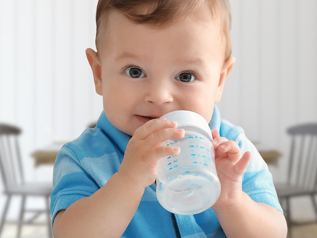 Un enfant qui boit avec un goblet/biberon