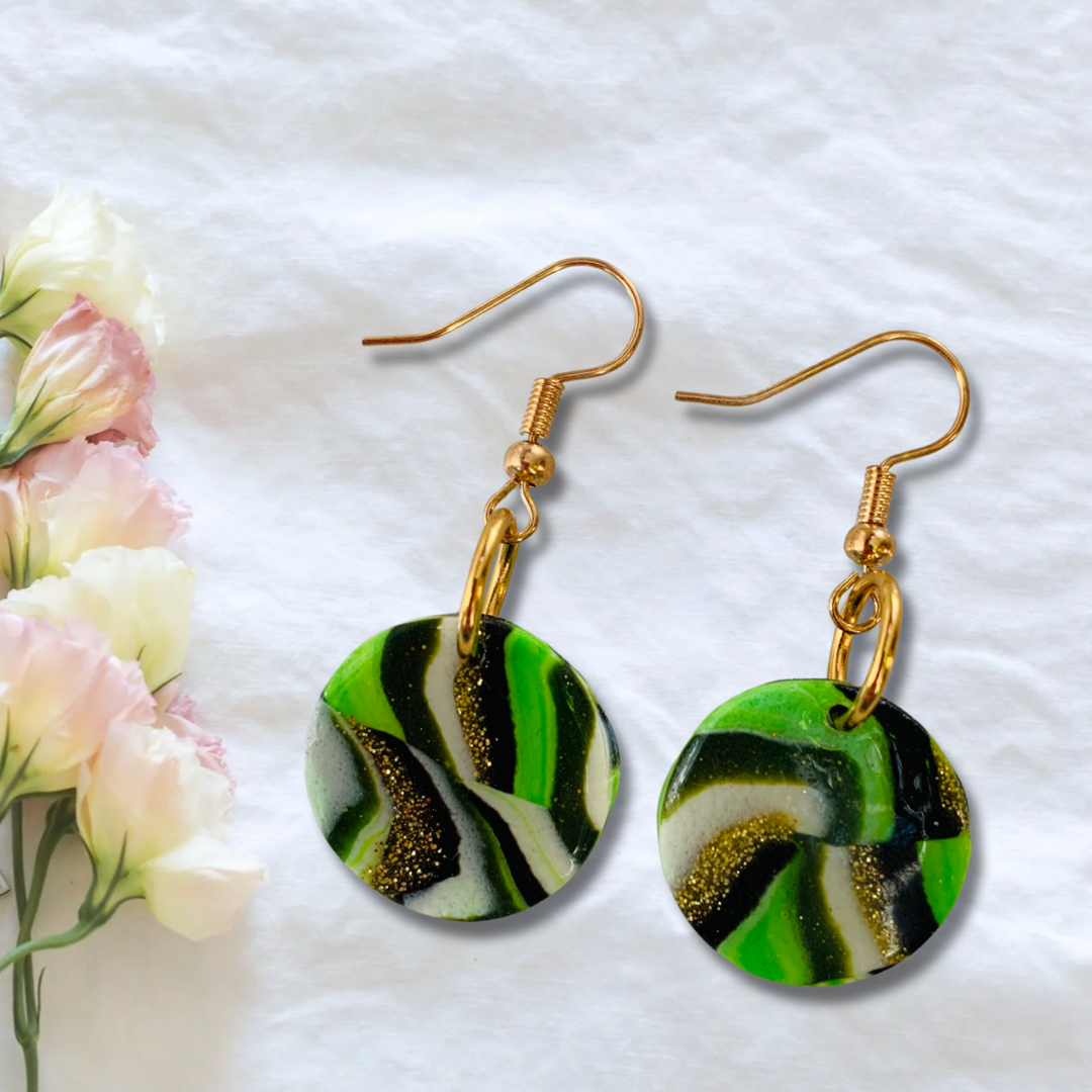 Boucles d'oreilles vertes blanches, noires et or pailletées.