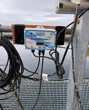 HBS AC power supply unit mounted at aquaculture site, powering ultrasonic algae control system for sustainable water treatment in fish farming operations.