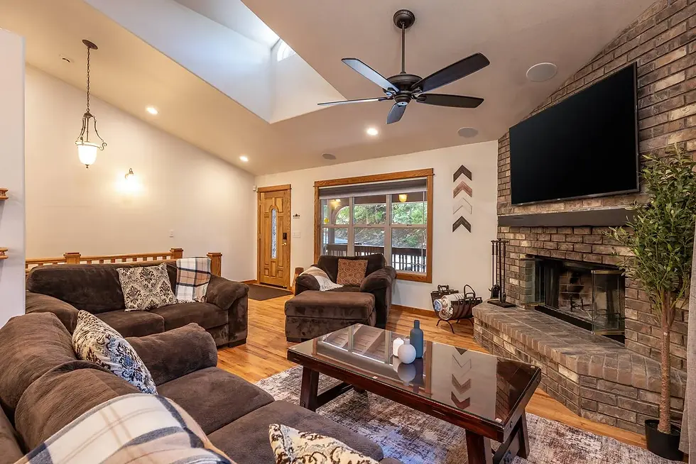 Modern San Diego property management home with spacious living room featuring brick fireplace, hardwood floors, and vaulted