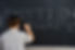 Boy Writing Hebrew Letters on Blackboard