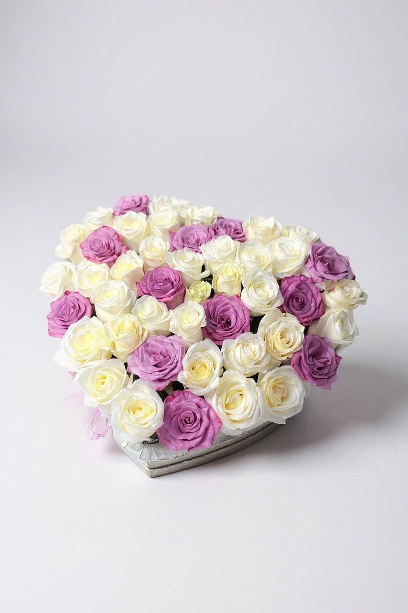 Heart-shaped arrangement of white and lavender roses designed in a modern Gloss Florist style.