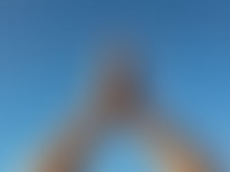 Hands joined in a gentle prayer position against a blue sky, symbolising balance, grounding and mindful Qigong posture.