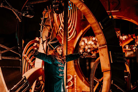 Acteur in kostuum voor een groot houten rad