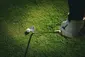 Golf trial class beginner practicing an iron shot on a golf course during a trial lesson.