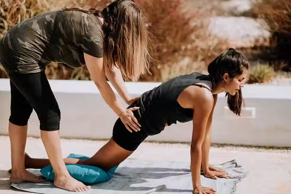 woman in black tank top and black shorts kneeling on mat
Two women working out together
