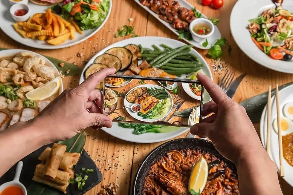 Person photographing a colorful food presentation for a guide to food licence types in Singapore.