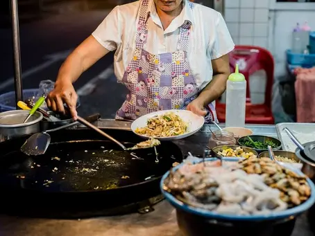 Street vendor skillfully whipping up a delicious meal in a bustling night market