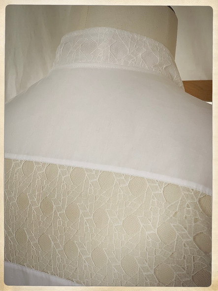 Chemise blanche à manches courtes et col mao, en popeline de coton biologique et dentelle de Calais-Caudry du dentellier Sophie Halette ; boutons carrés en nacre véritable.