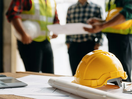 Engineer teams meeting working together wear worker helmets hardhat on construction site in modern city.Asian industry professional team in sun light