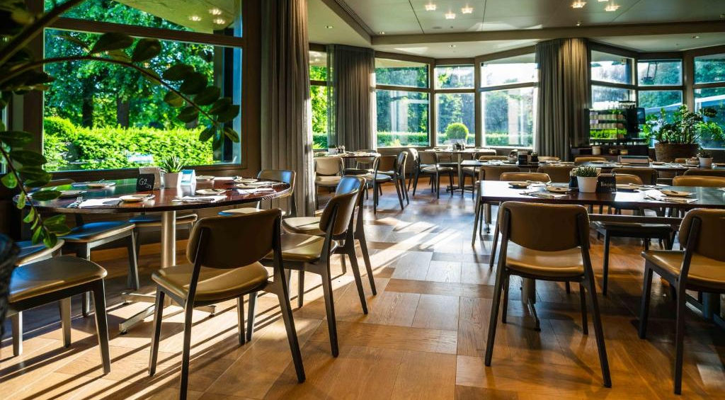 Heller Restaurantraum mit Blick auf grüne Bäume
