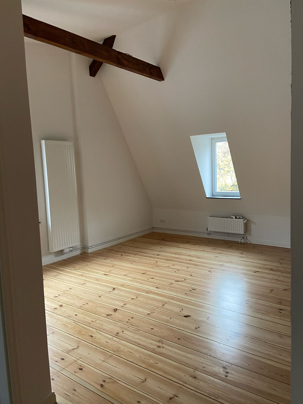 Leeres Dachzimmer mit Holzboden für Malerarbeiten