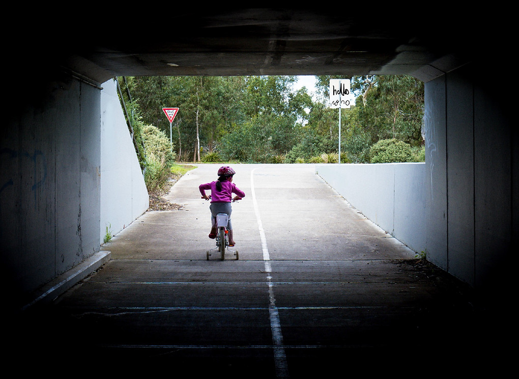Girl riding her bike under tunnel in a park in Melbourne
