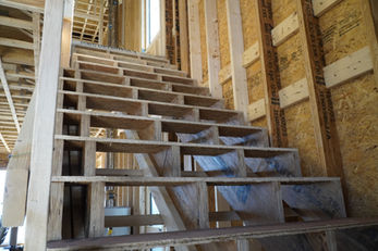 Unfinished wood stair framing inside the home during construction