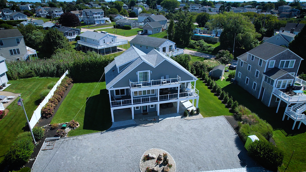 Finished gray coastal home on columns with wraparound decks at 144 Saltaire Ave. in Narragansett, RI