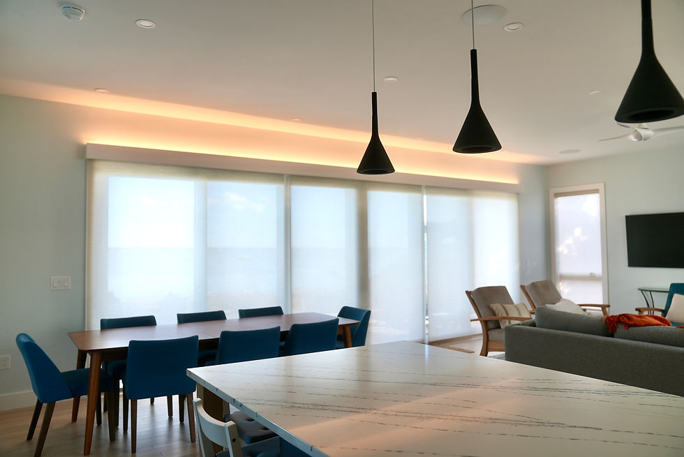 Open living and dining area with large windows and pendant lights in a custom home