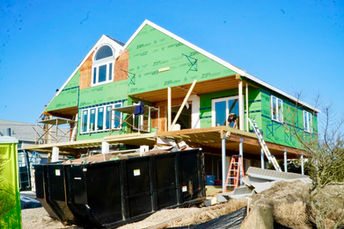 Dumpster and ladders beside the elevated home during the full-house renovation at 144 Saltaire Ave.