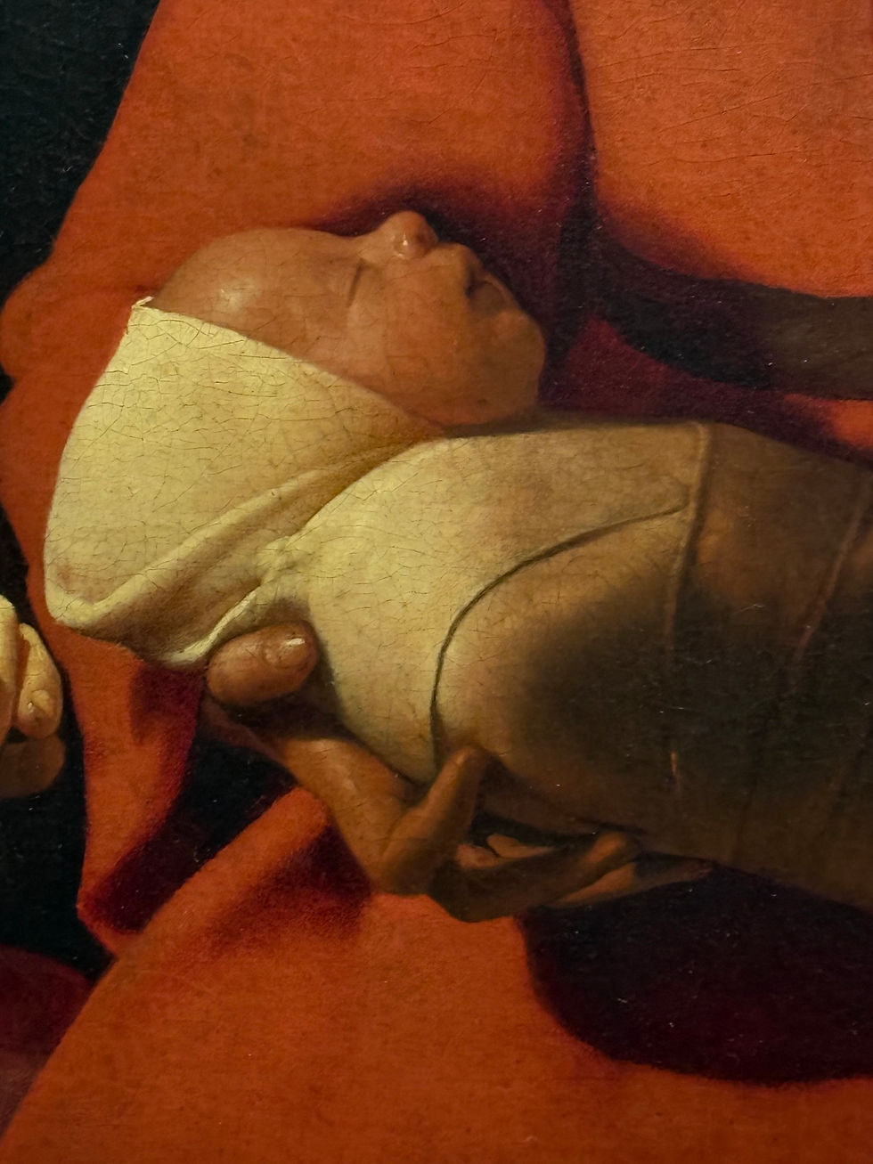 Realistycznie namalowany noworodek, jeden z pierwszych w historii zachodniego malarstwa. Szczelnie owinięty w pieluszki, zgodnie ze zwyczajem epoki.