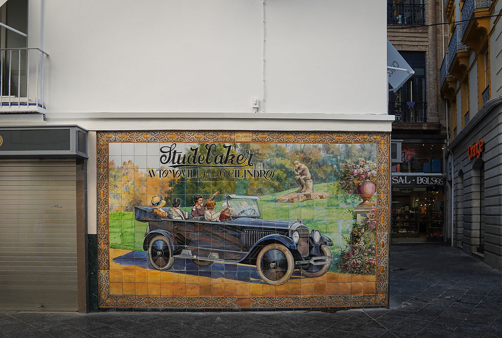 Mozaika na ścianie przedstawia zabytkowy samochód  pełen pasażerów. Tekst: "Studebaker Automovil de 6 Cilindro".