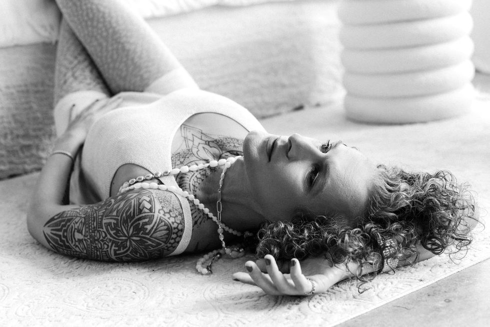 Transgender editorial muse reclining on floor in soft natural light