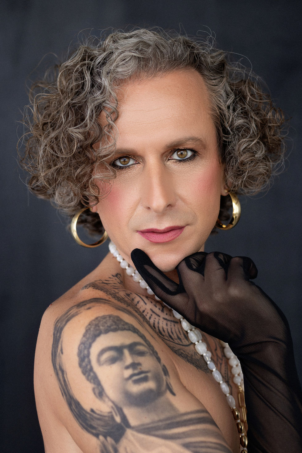 Intimate close-up featuring tattoo and piercing eyes, strength meets softness