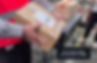 A man holding a parcel with a label over the joins. Example of a parcel requiring manual processing due to a label misplacement.