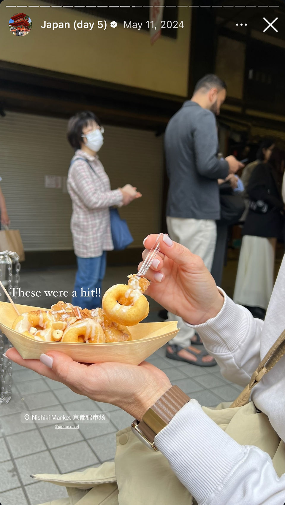 woman eats japanese doughnuts at nikishi market in kyoto japan
