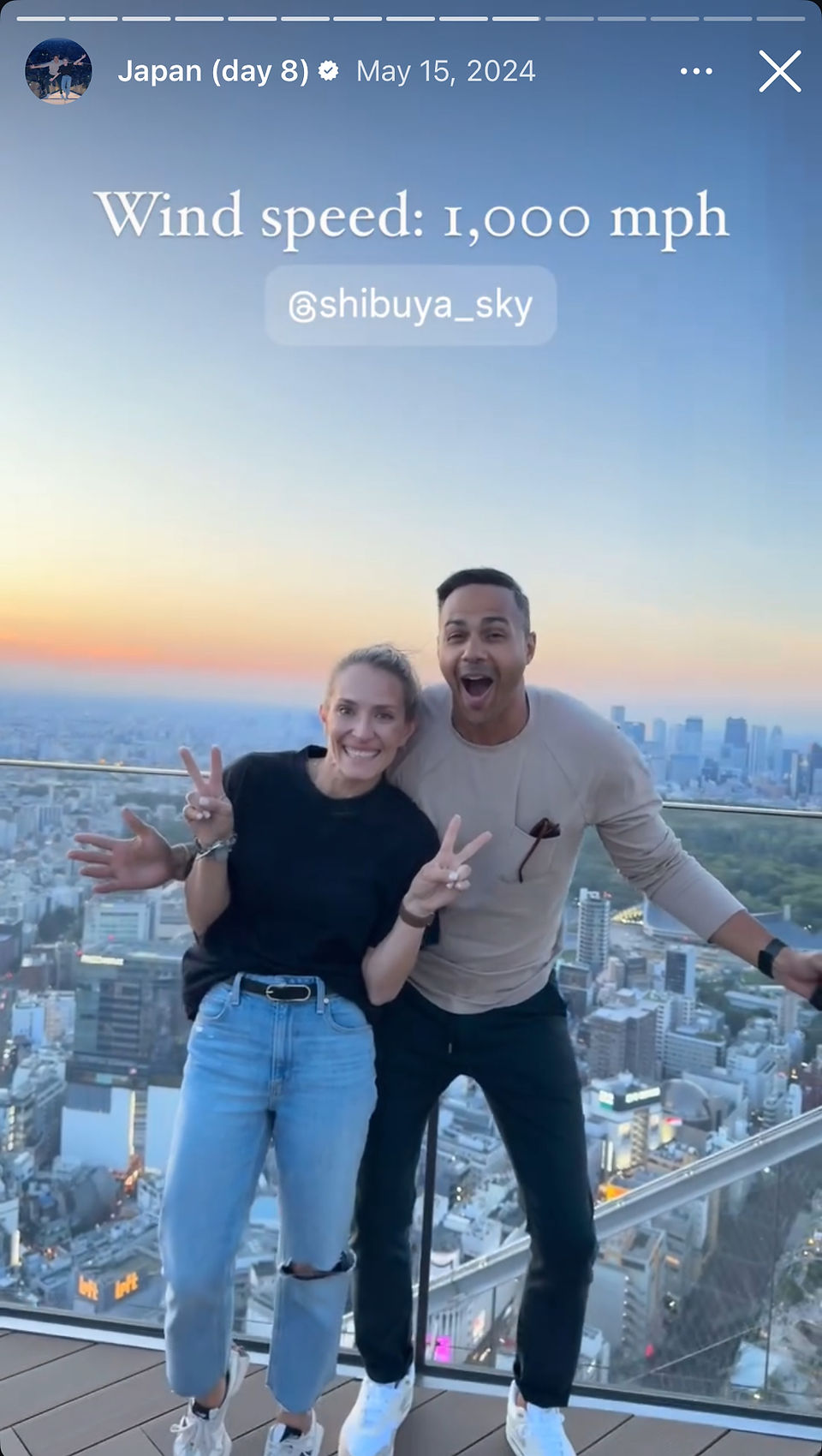 man and woman on top of shibuya sky in tokyo with skyline sunset in background