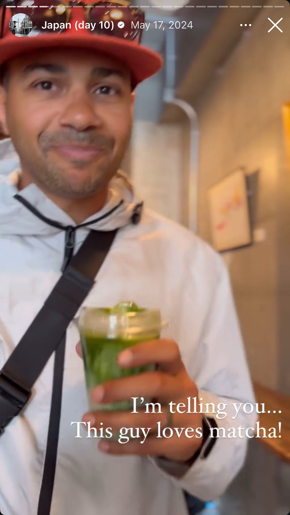 man smiling in cafe with matcha latte in hand