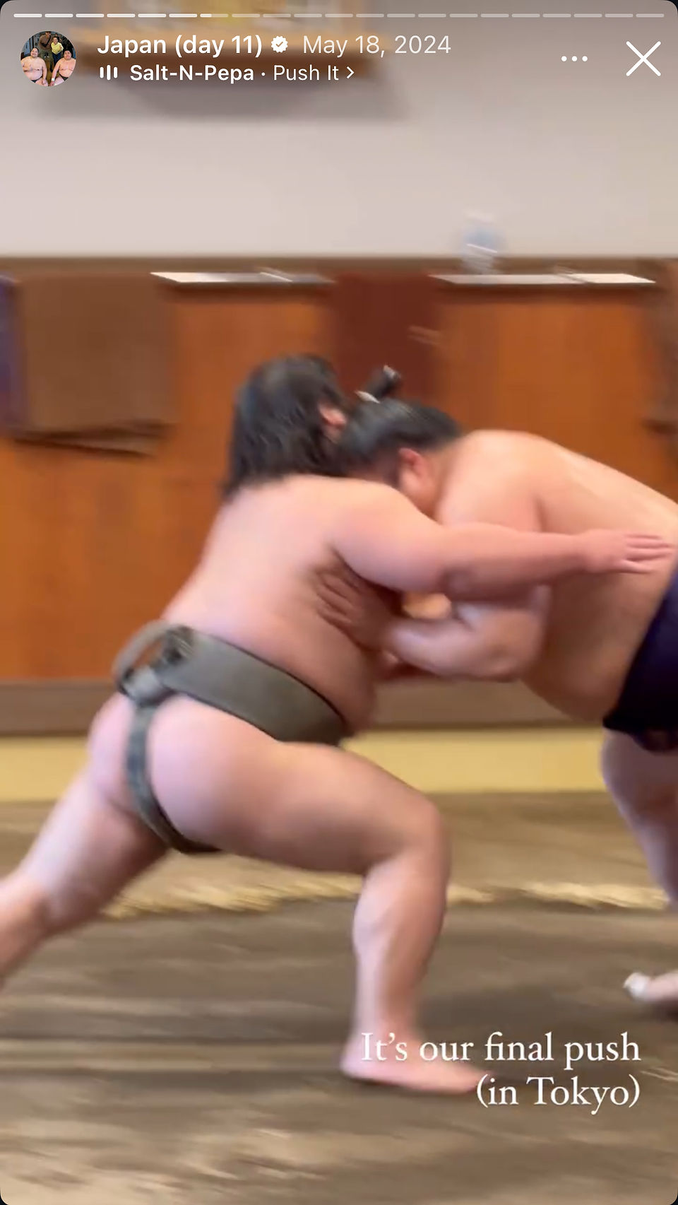 two sumo wrestler pushing at each other intensely